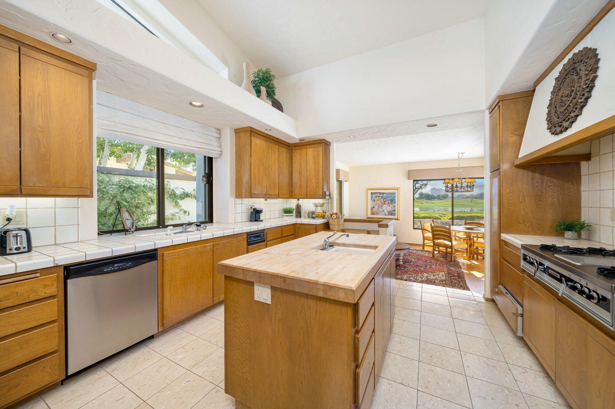 55880 Pinehurst La Quinta, CA 92253 - Photo 26 of 54 a kitchen with stainless steel appliances granite countertop a sink and cabinets