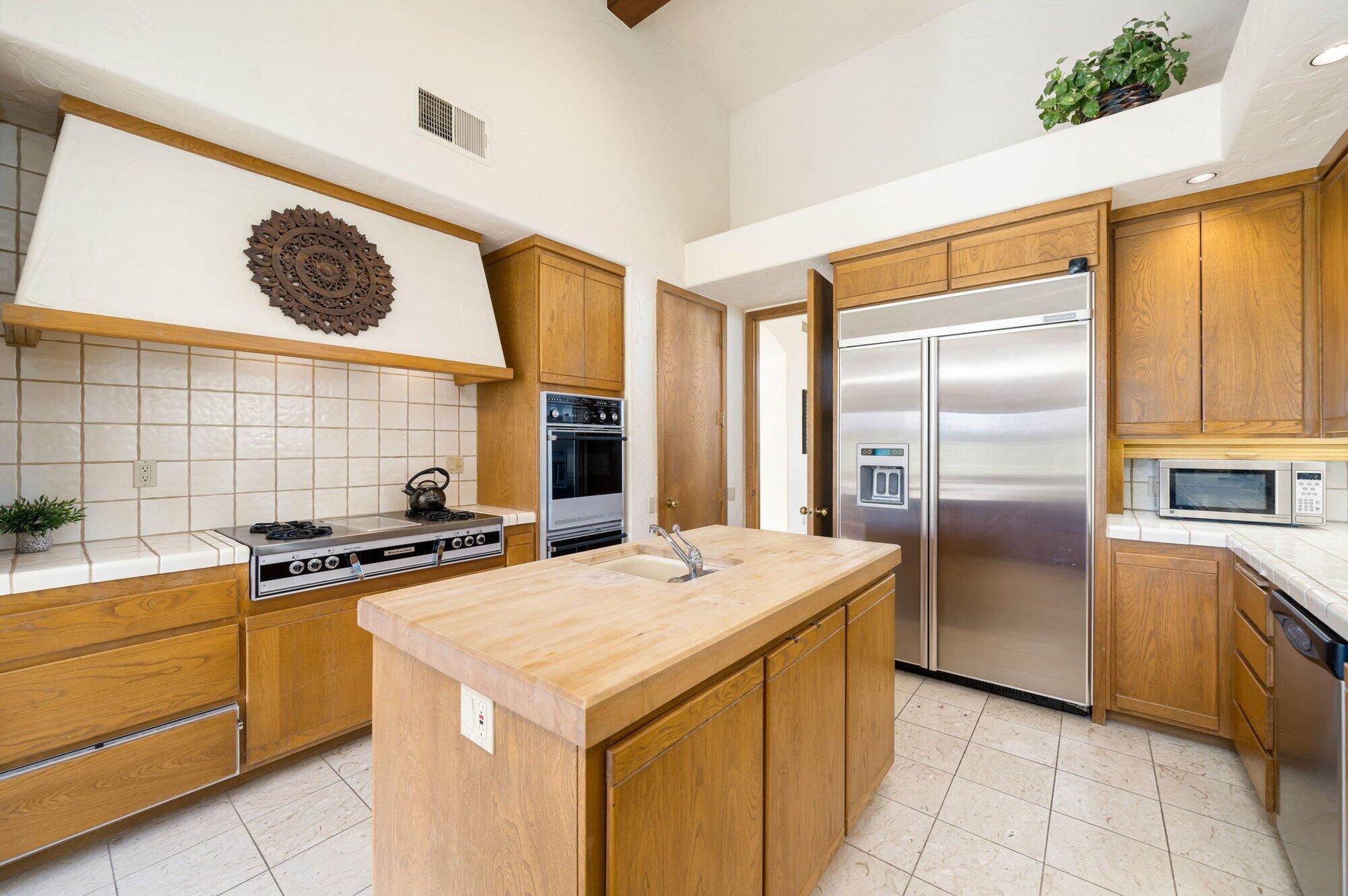 55880 Pinehurst La Quinta, CA 92253 - Photo 28 of 54 a kitchen with stainless steel appliances a stove a refrigerator and a sink