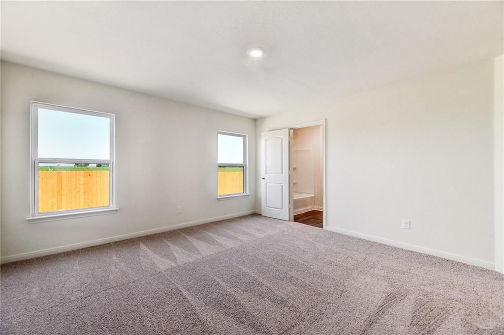 14008 Prospector Way Elgin, TX 78621 - Photo 4 of 7 an empty room with a window and a fireplace