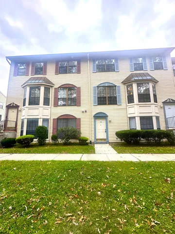 a front view of residential houses with yard and green space
