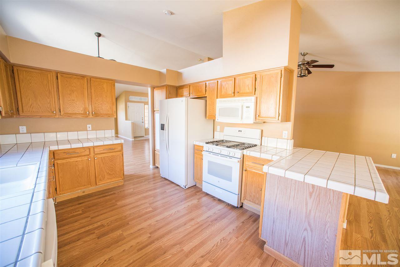 1980 Honey Ridge Drive Reno, NV 89511 - Photo 8 of 31 a kitchen with a wooden floor and white appliances