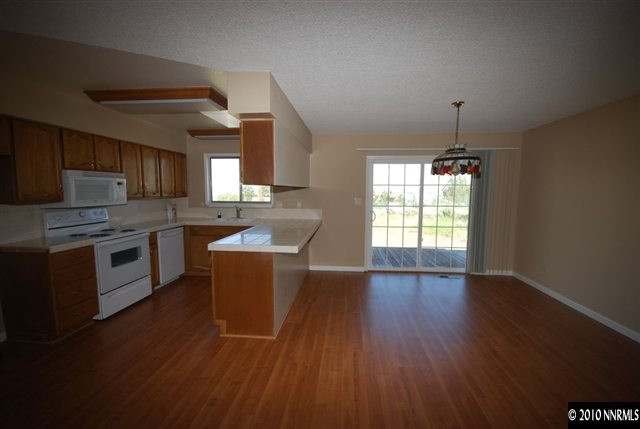 10505 Wells Fargo Road Reno, NV 89508 - Photo 3 of 9 a kitchen with stainless steel appliances wooden floors and wooden cabinets