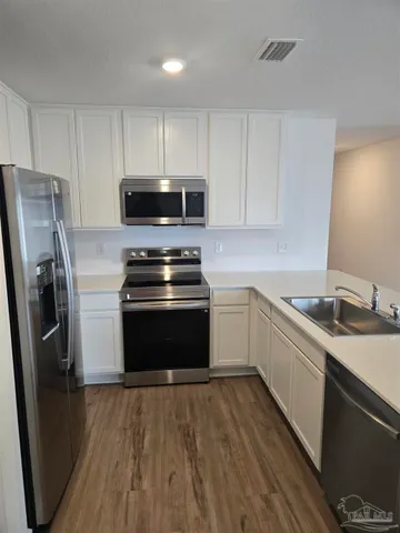 a kitchen with a sink stove and refrigerator