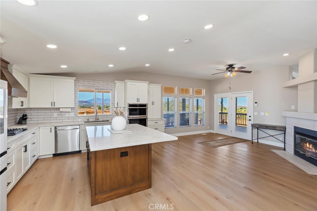 19310 Ann Way Perris, CA 92570 - Photo 13 of 75 a kitchen with stainless steel appliances granite countertop a refrigerator a sink dishwasher a stove and white cabinets with wooden floor