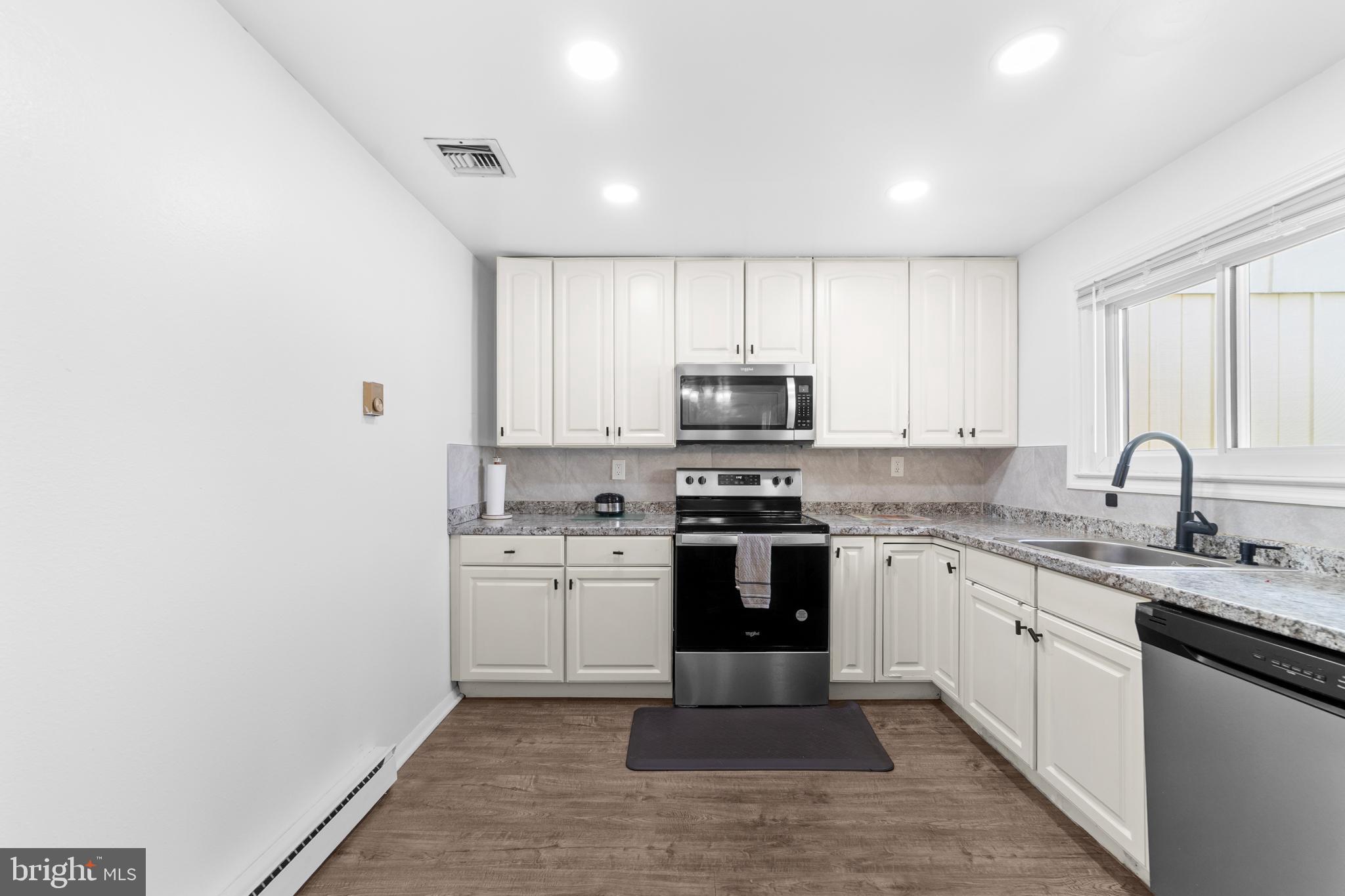 25C Pitman Road, Unit B Monroe Township, NJ 08831 - Photo 12 of 29 a kitchen with stainless steel appliances granite countertop a stove top oven a sink and dishwasher