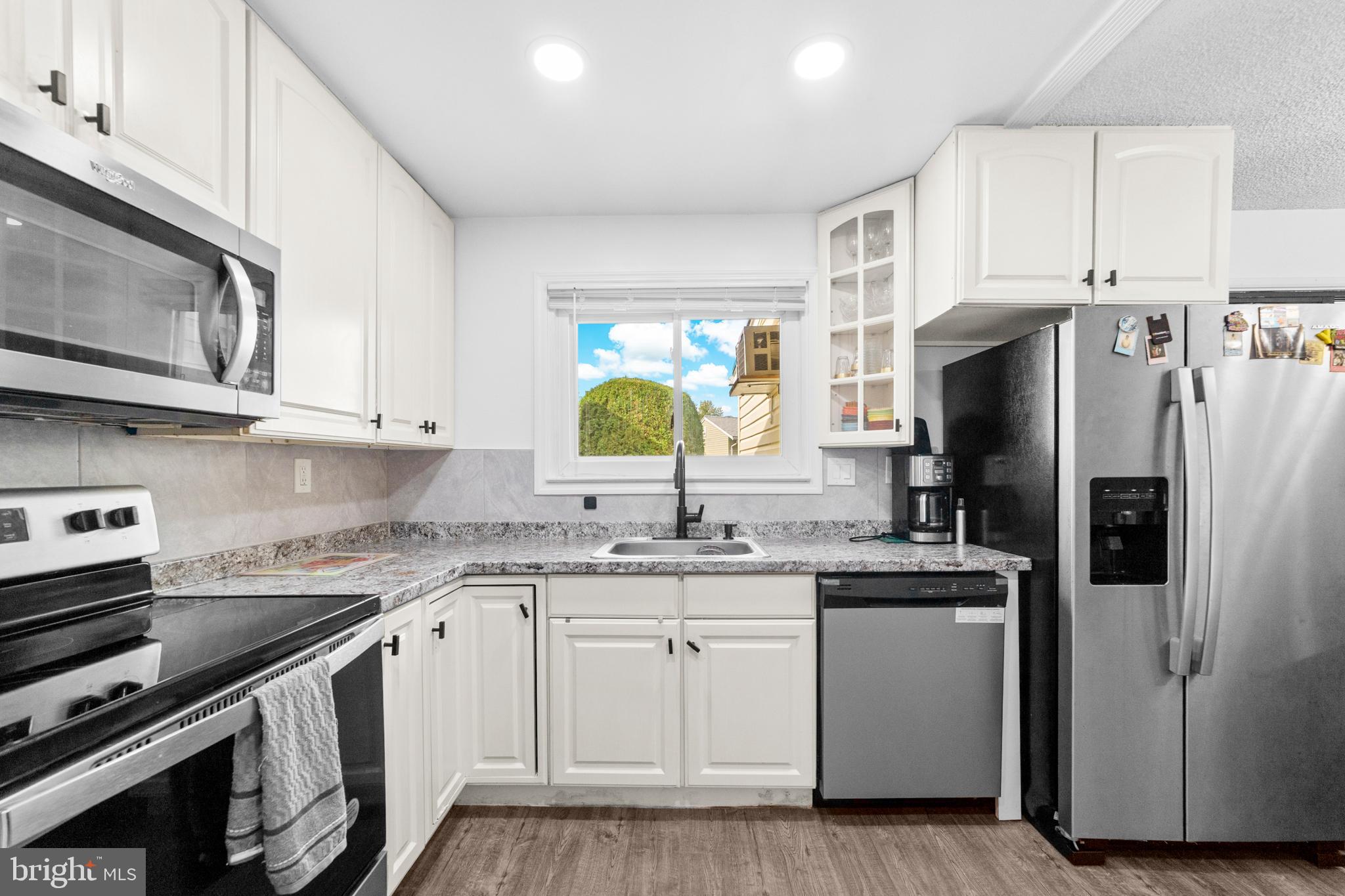 25C Pitman Road, Unit B Monroe Township, NJ 08831 - Photo 13 of 29 a kitchen with stainless steel appliances a sink a stove a refrigerator cabinets and a window
