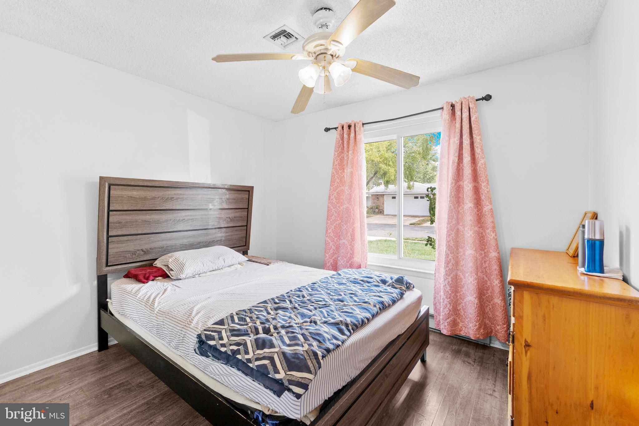 25C Pitman Road, Unit B Monroe Township, NJ 08831 - Photo 19 of 29 a bedroom with a bed and a chandelier
