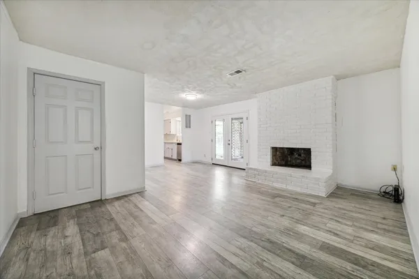 a view of empty room with wooden floor and fireplace