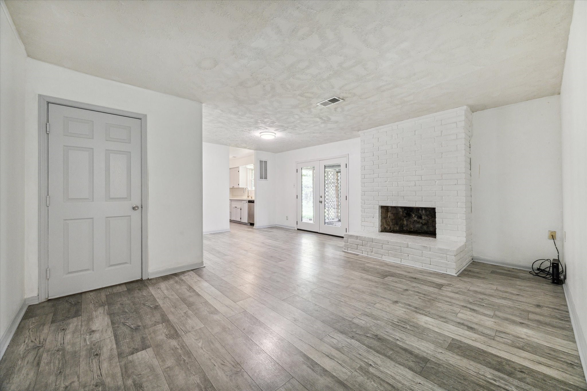 a view of empty room with wooden floor and fireplace