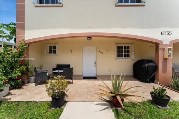 a front view of a house with outdoor seating and plants