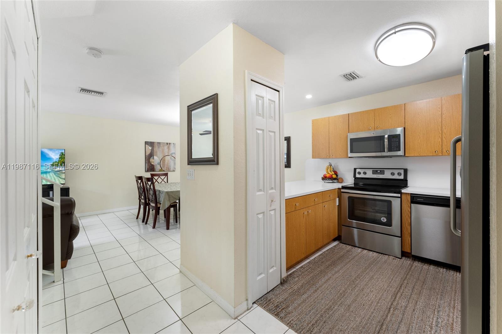 6755 Northwest 182nd Street, Unit 104 Hialeah, FL 33015 - Photo 16 of 33 a kitchen with granite countertop a stove and a refrigerator