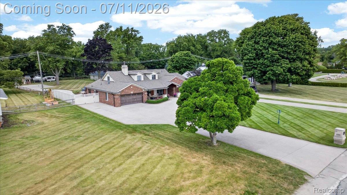 23750 East River Road Grosse Ile, MI 48138 - Photo 45 of 54 Brick exterior residence featuring a grey shingle roof, multiple dormer windows, and an attached two-car garage