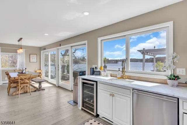 a open dining hall with stainless steel appliances granite countertop a stove and wooden cabinets with wooden floor