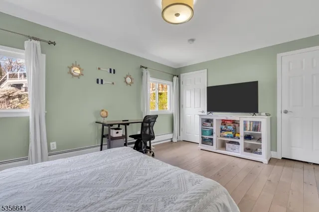 a bedroom with furniture and a flat screen tv