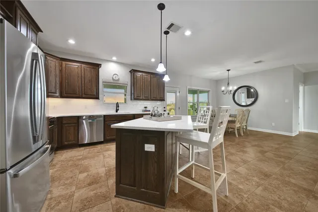 a kitchen with stainless steel appliances kitchen island granite countertop a sink counter space and cabinets