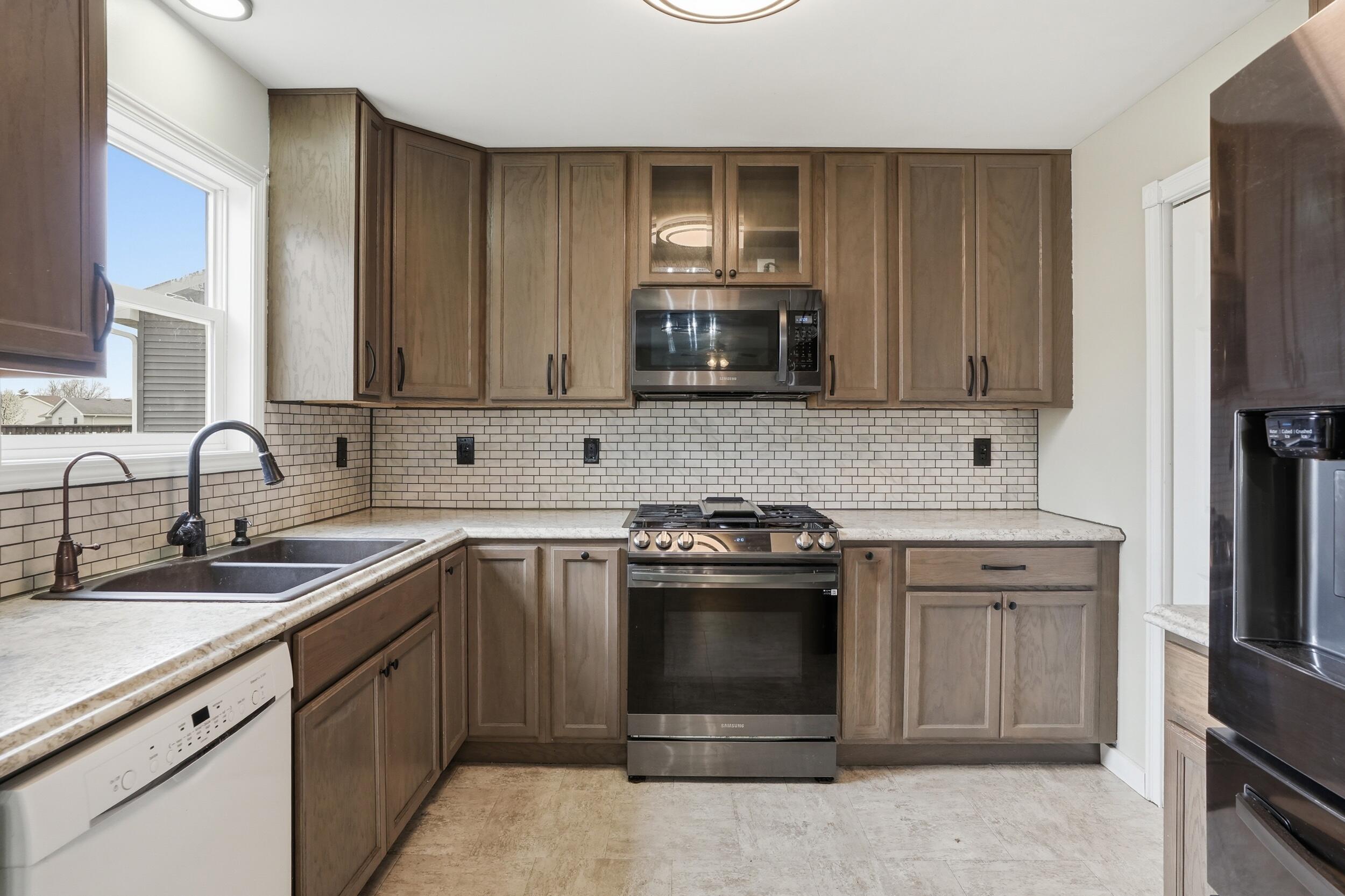 12358 Tippecanoe Place Crown Point, IN 46307 - Photo 11 of 30 a kitchen with stainless steel appliances granite countertop a sink stove and refrigerator