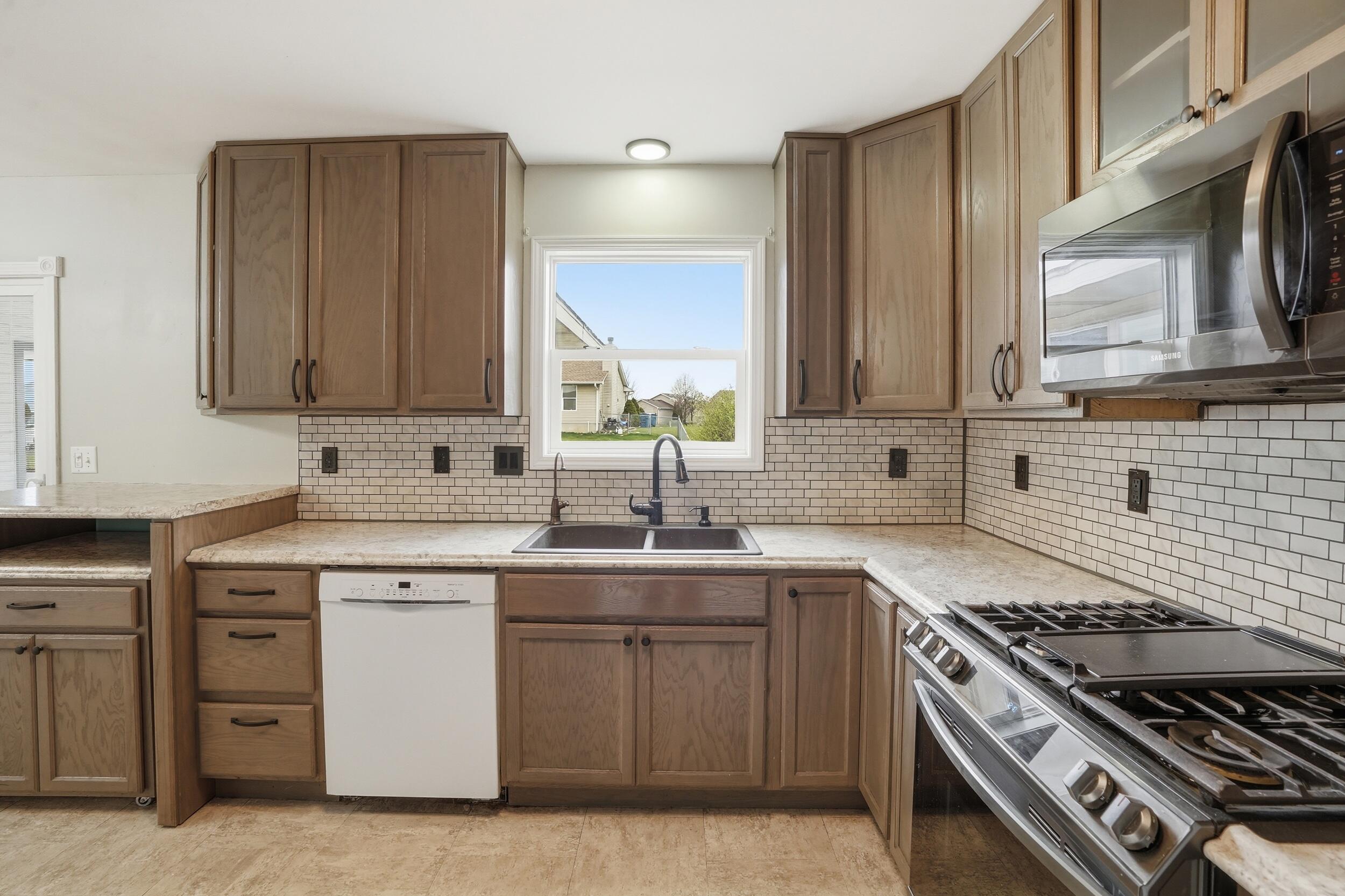 12358 Tippecanoe Place Crown Point, IN 46307 - Photo 12 of 30 a kitchen with cabinets appliances a sink and a window