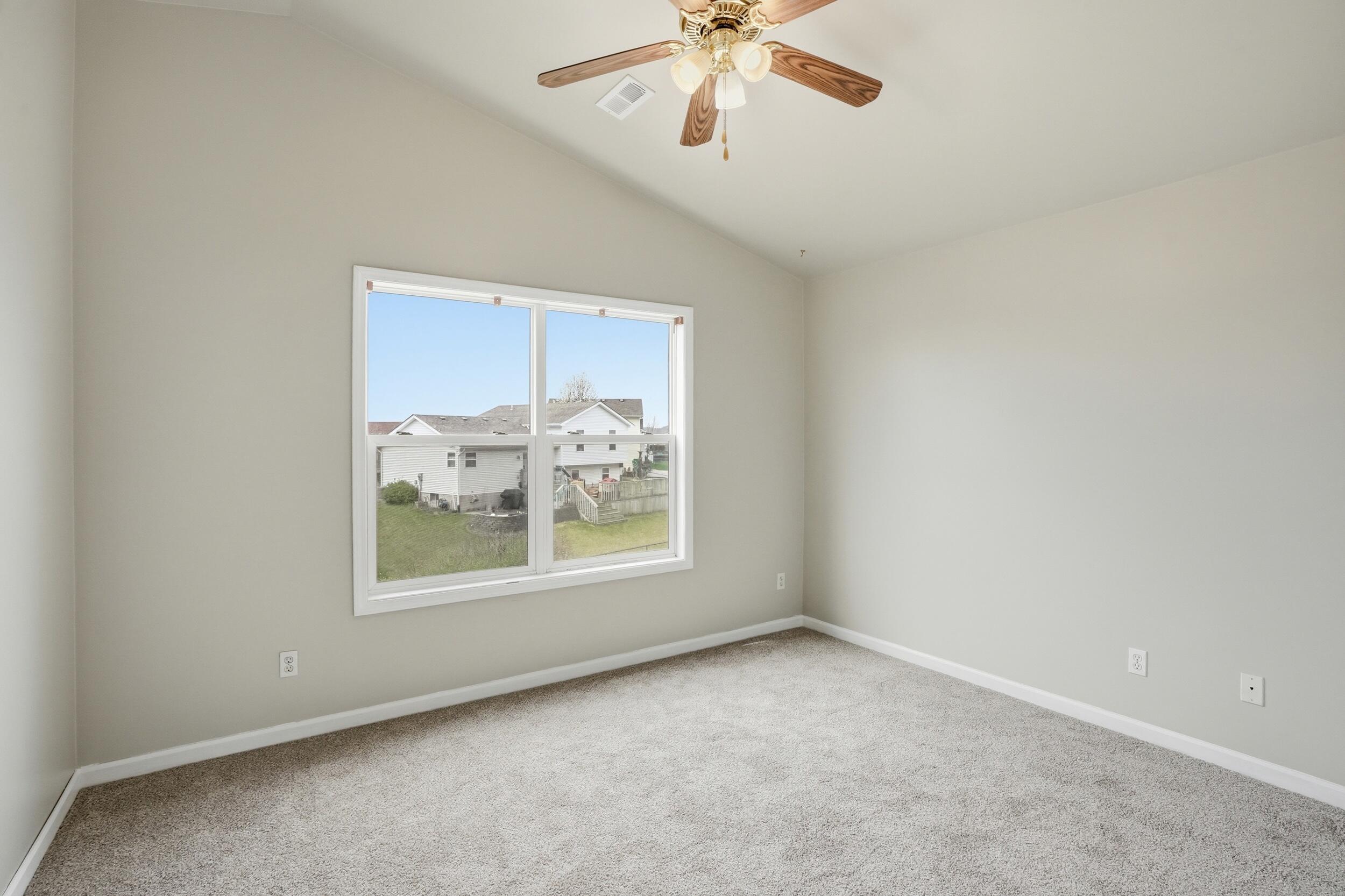 12358 Tippecanoe Place Crown Point, IN 46307 - Photo 18 of 30 an empty room with windows and a chandelier fan