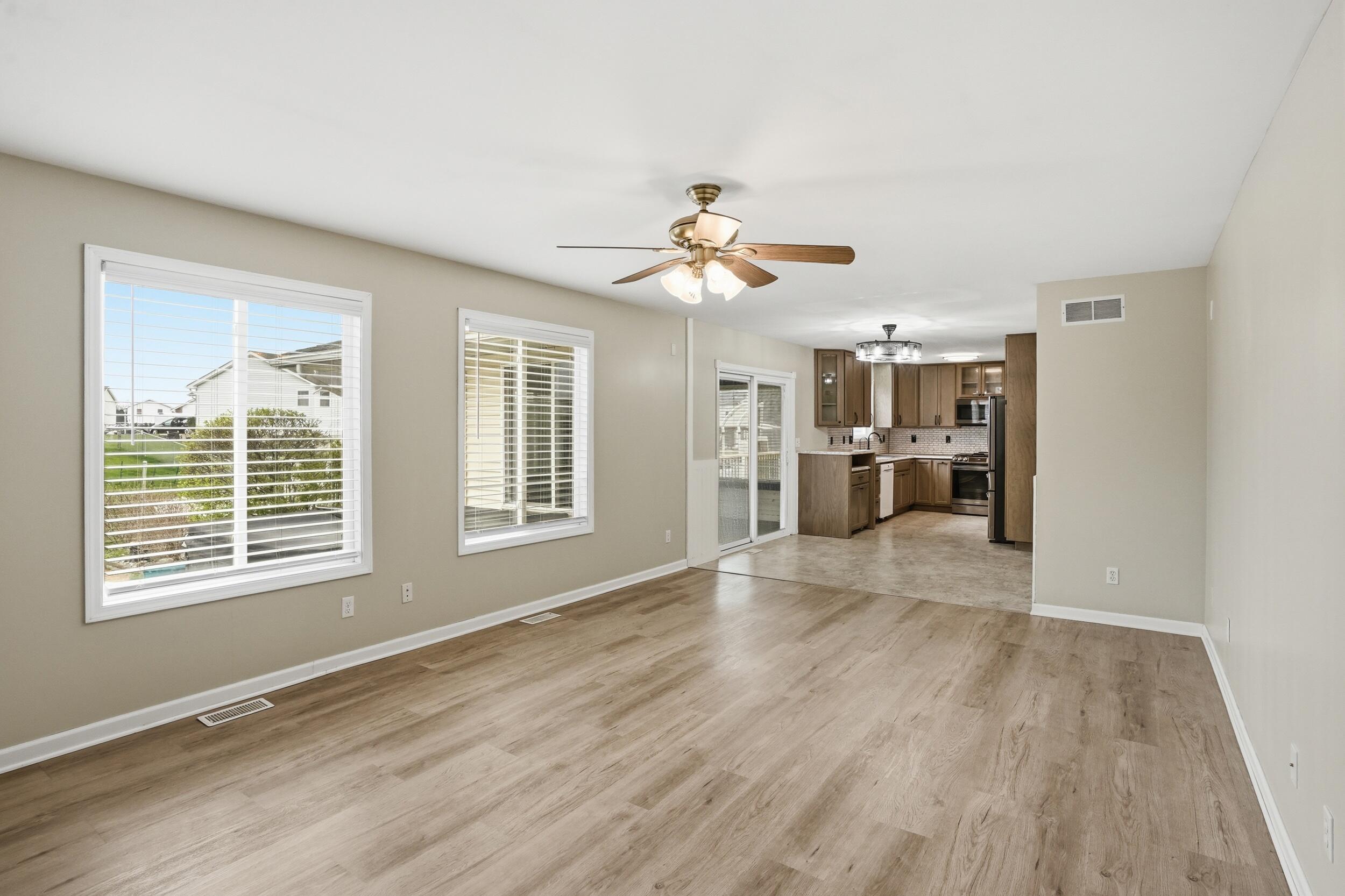 12358 Tippecanoe Place Crown Point, IN 46307 - Photo 9 of 30 a view of an empty room with a kitchen and wooden floor