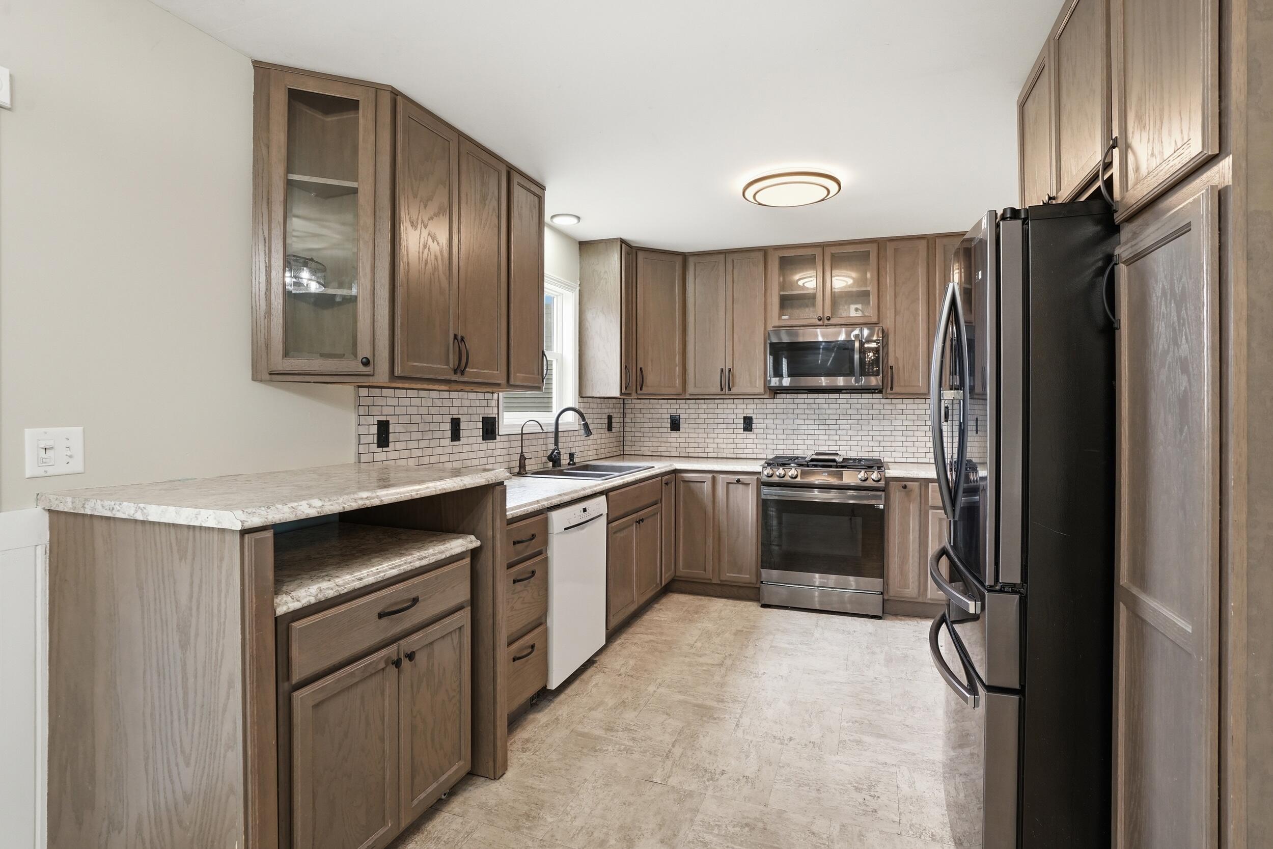 12358 Tippecanoe Place Crown Point, IN 46307 - Photo 10 of 30 a kitchen with stainless steel appliances granite countertop a refrigerator stove and sink