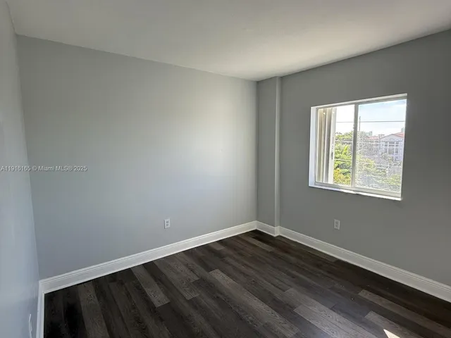 a view of a room with wooden floor and windows