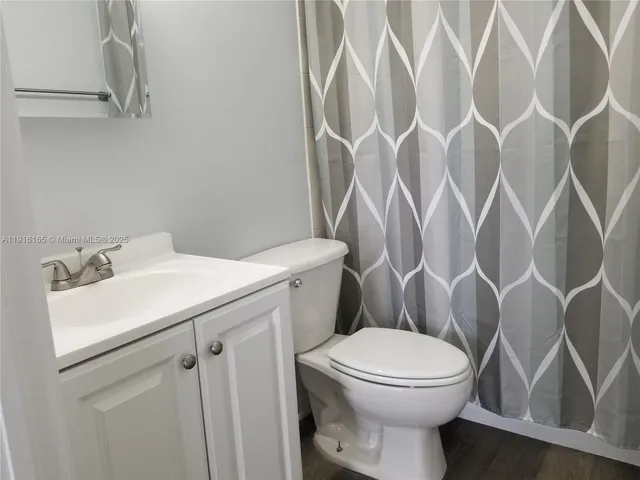 a bathroom with a sink and mirror with toilet