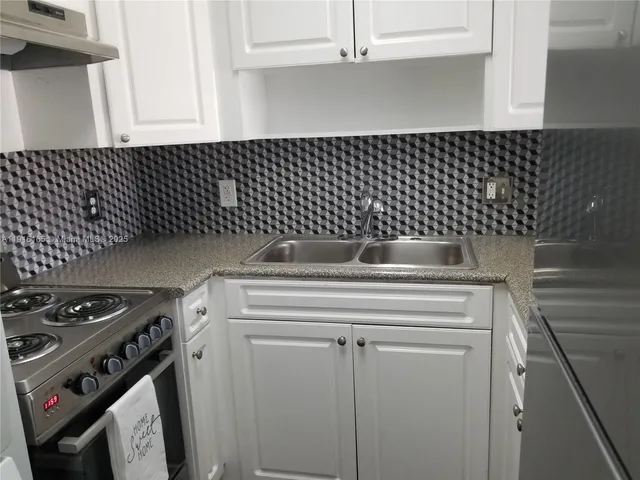 a kitchen with a sink a stove and cabinets