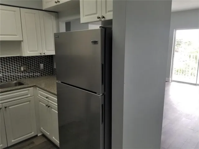a white refrigerator freezer sitting inside of a kitchen