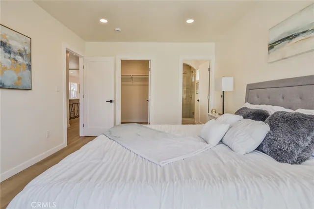 a bedroom with a large bed and a painting on the wall