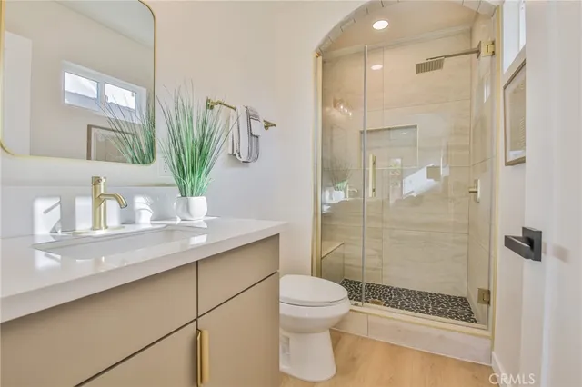 a bathroom with a granite countertop sink a toilet and shower