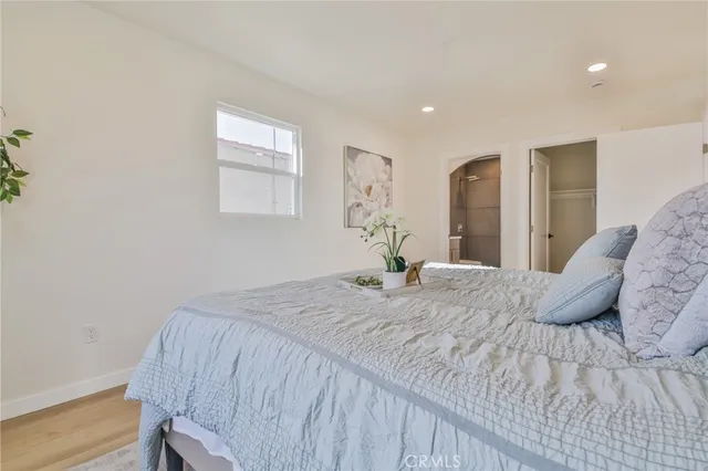 a bedroom with a bed and wooden floor