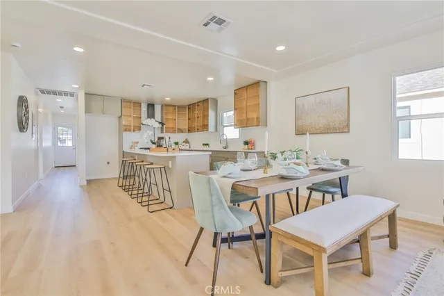 a dining room with stainless steel appliances a dining table chairs and window
