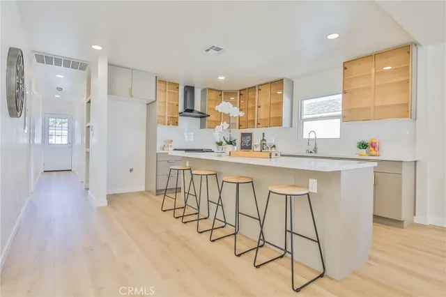 a kitchen with stainless steel appliances a sink cabinets and wooden floor