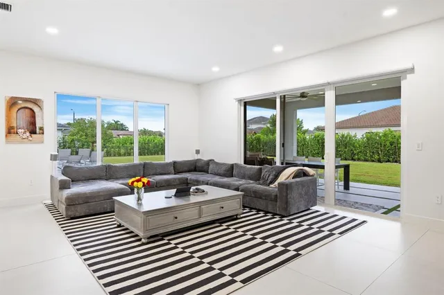 a living room with furniture and a floor to ceiling window