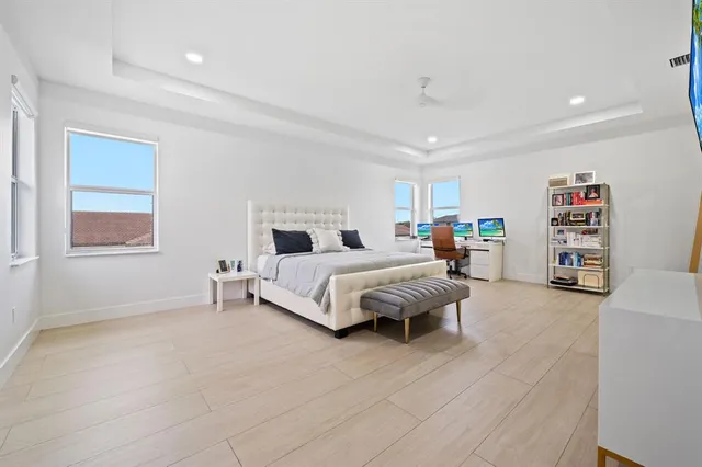 a spacious bedroom with a bed a couch and a window