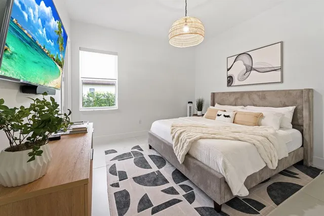 a bedroom with a bed and a potted plant