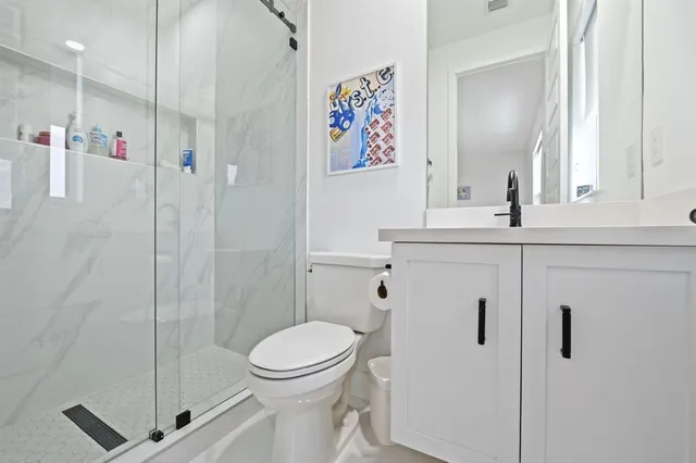 a bathroom with a shower a toilet and a sink