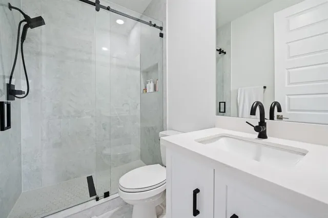 a bathroom with a sink a toilet and shower