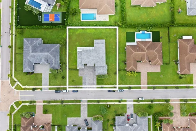 an aerial view of a house with a garden and lake view