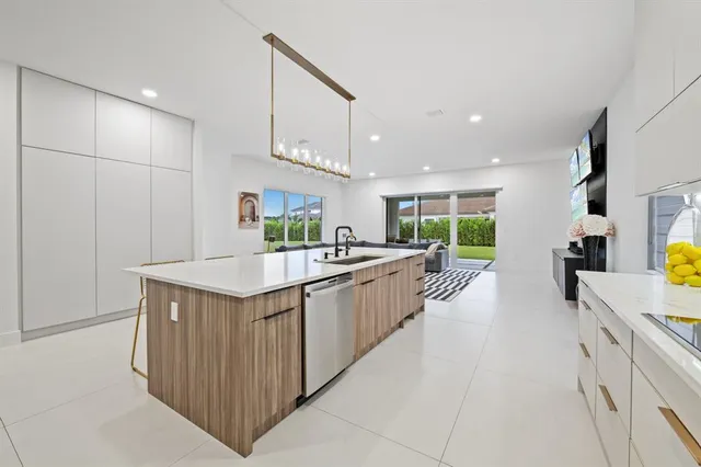 a kitchen with stainless steel appliances granite countertop a sink and a refrigerator