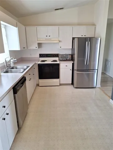 a kitchen with white cabinets and white appliances