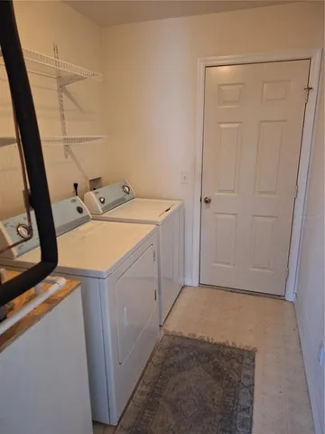a view of a house with a big yard and large trees