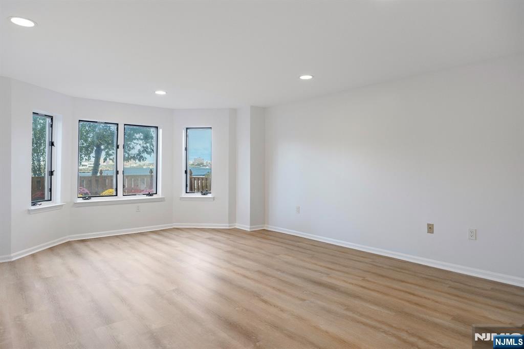 105 Nelson Court Edgewater, NJ 07020 - Photo 12 of 18 a view of an empty room with wooden floor and a window