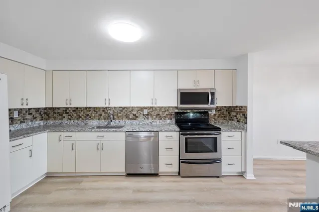 a kitchen with granite countertop a stove and a sink