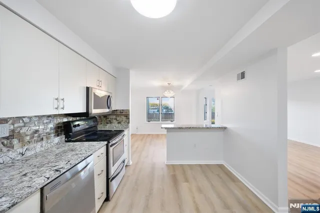 a kitchen with stainless steel appliances granite countertop a sink stove and cabinets