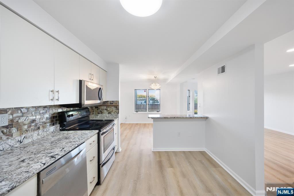 105 Nelson Court Edgewater, NJ 07020 - Photo 7 of 18 a kitchen with stainless steel appliances granite countertop a sink stove and cabinets