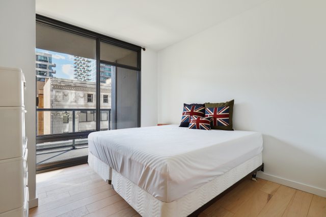 100 East 14th Street, Unit 708 Chicago, IL 60605 - Photo 13 of 25 a large bed sitting in a bedroom next to a window