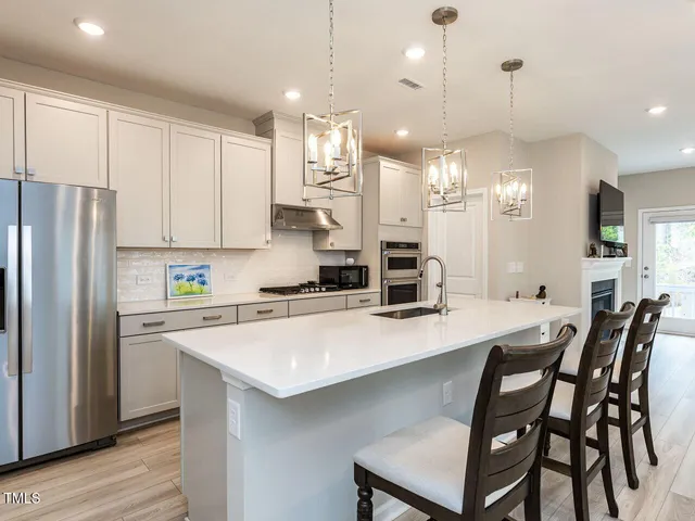 a open kitchen with white cabinets and stainless steel appliances