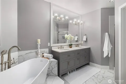 a bathroom with a double vanity sink mirror and bathtub