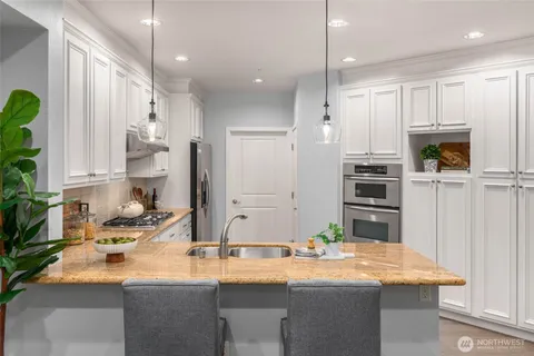 a kitchen with stainless steel appliances kitchen island granite countertop a sink and cabinets